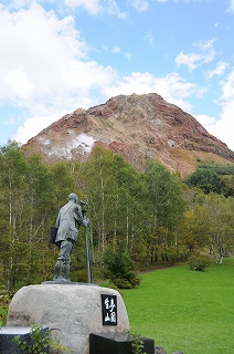 昭和新山を見守るように建つ三松正夫さんの銅像