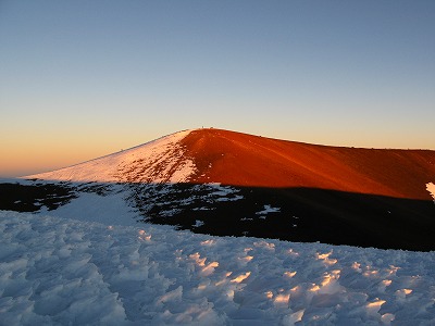夕陽を浴びるマウナ・ケア山頂と雪